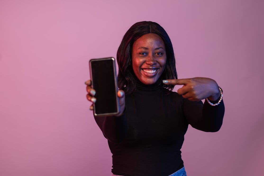 happy young black lady showing her phone screen